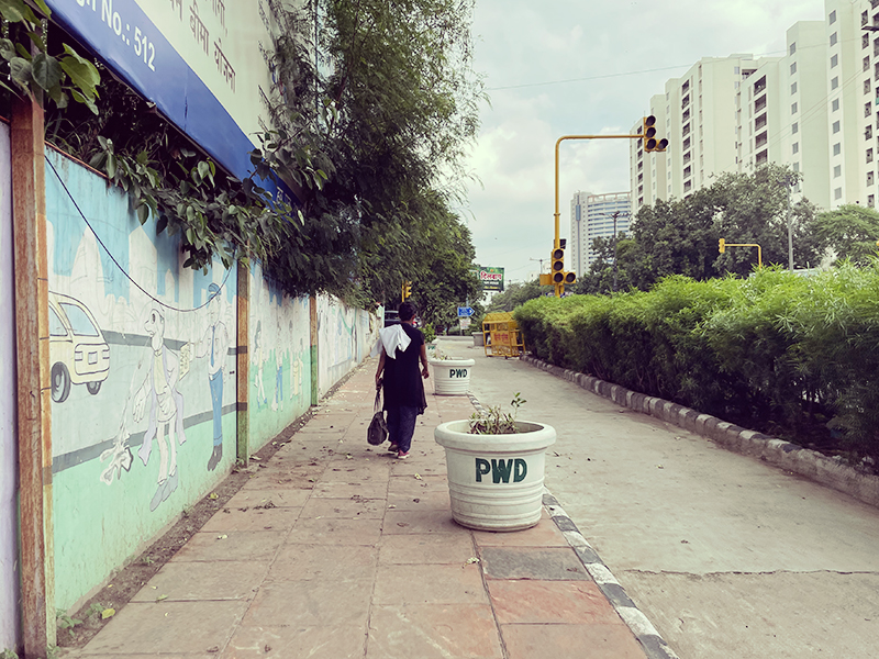 デリー・コンノートプレイスで女性の後ろをついて歩く旅行者の風景